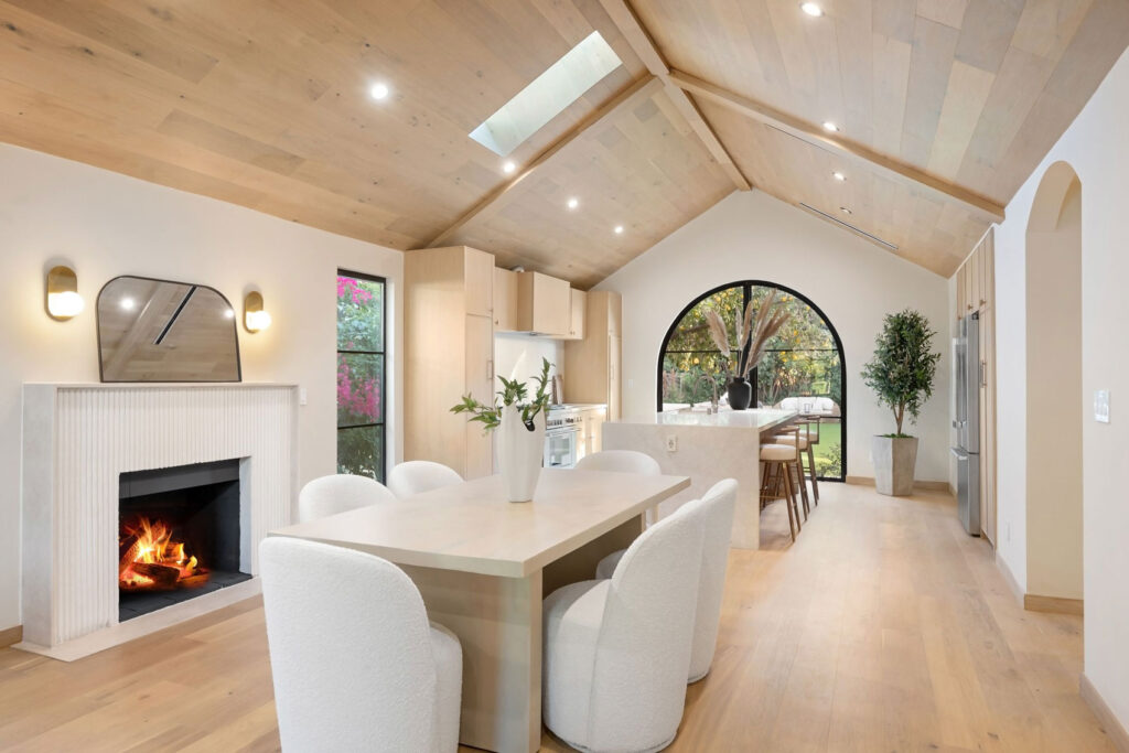 Contemporary home remodeling in Evanston, IL, by Hammell Homes. - Hammell Homes | Hammell Homes Modern, open-concept dining and kitchen area with a vaulted wood ceiling and fireplace, in home remodeling in Evanston, IL.