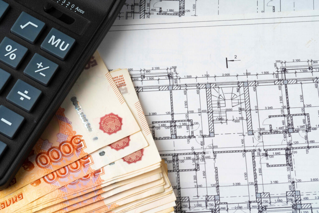 Russian roubles stack on blueprints wth calculator Renovation building expenses concept - Hammell Homes | Hammell Homes | Hammell Homes