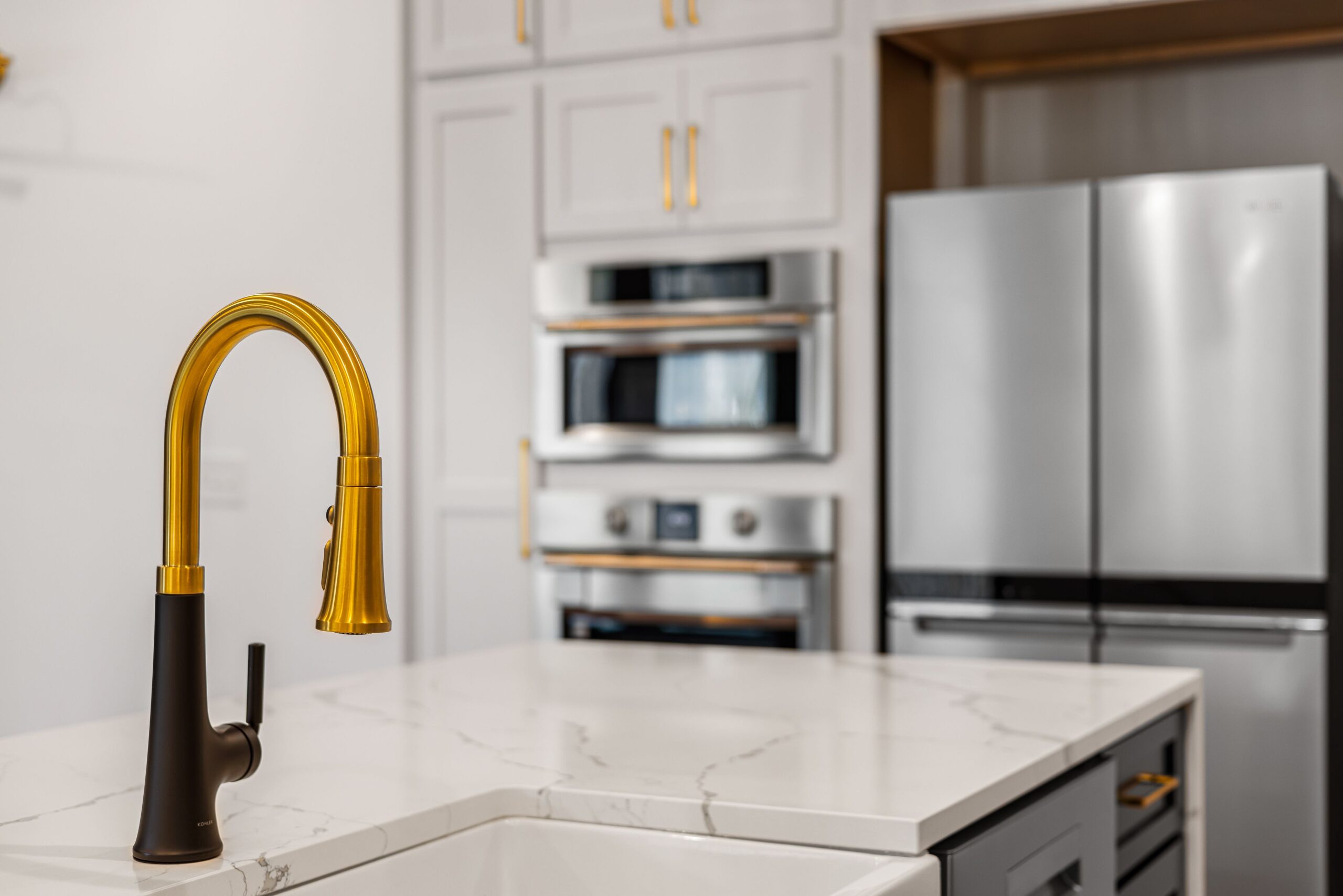 July Kitchen Remodeling in Chicago: Heat, Permits & Timeline 1 Elegant kitchen interior with a modern gold faucet and sleek stainless steel appliances.