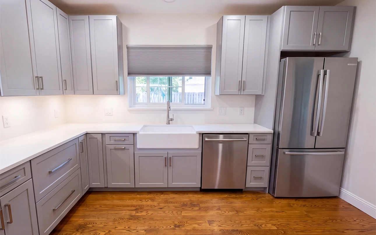 The same sink wall earlier in the remodel, with the cabinets and quartz countertops set and the wall above the counter still bare